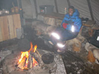 Nikki warming herself by the bonfire