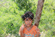 A young girl outside the fence at the killing fields outside Phnom Penh in Cambodia