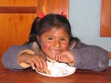 Young girl enjoying a cake at the school in El Alto